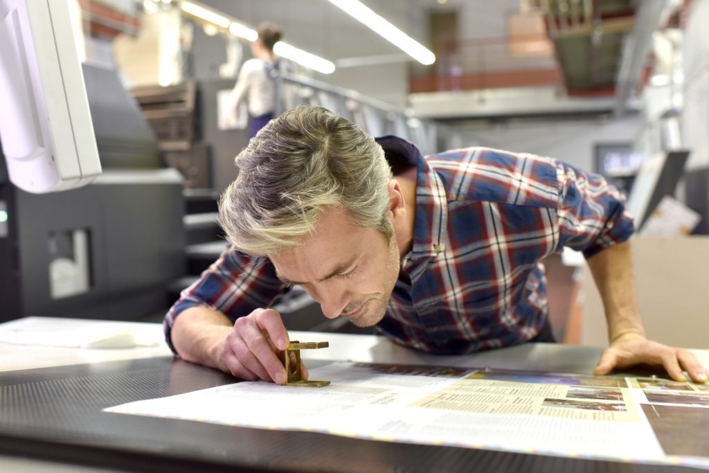 man inspecting prints