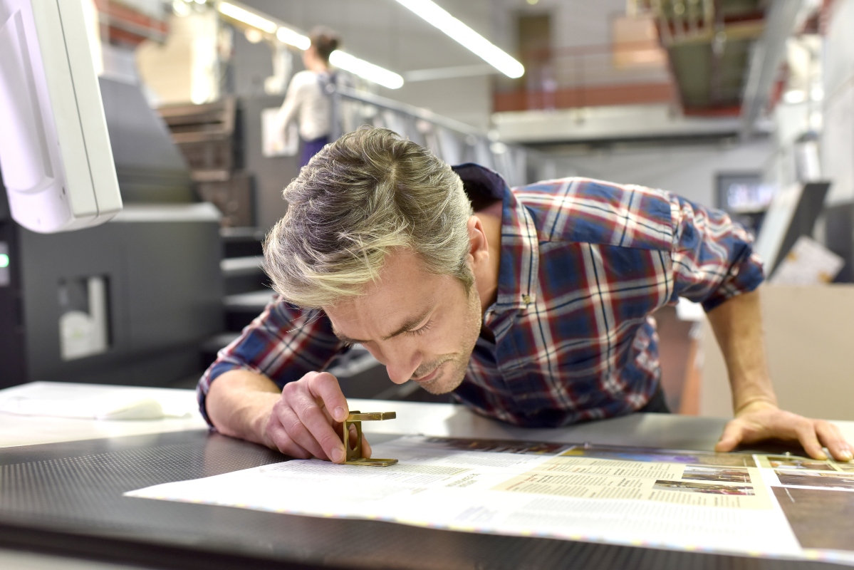 man inspecting prints