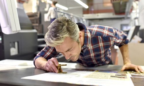 man inspecting prints